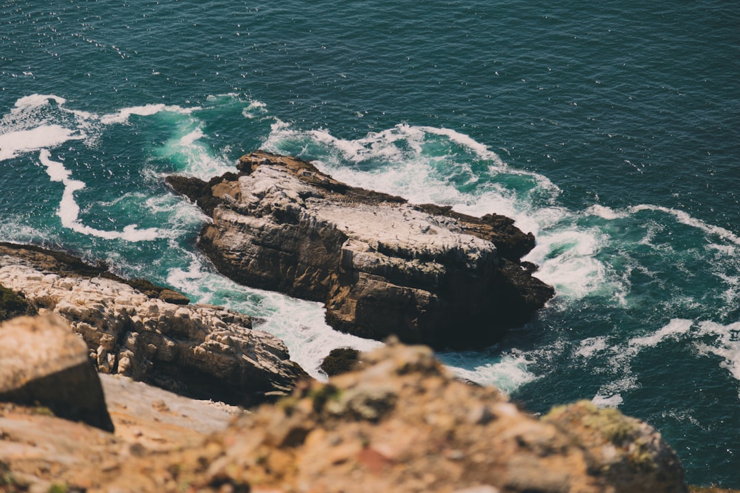 rock formation on body of water during daytime