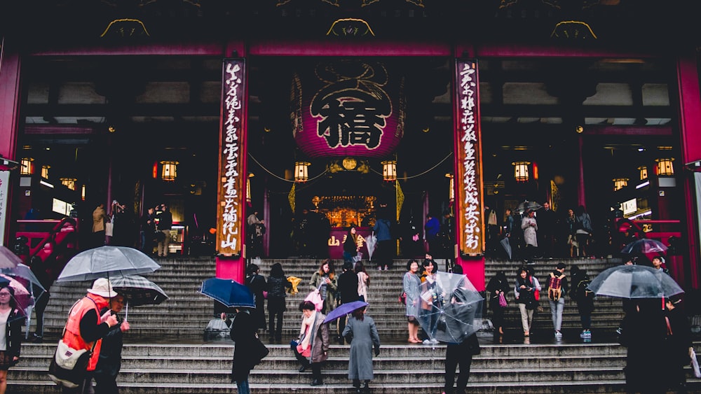 people walking on concrete stairs in front of temple