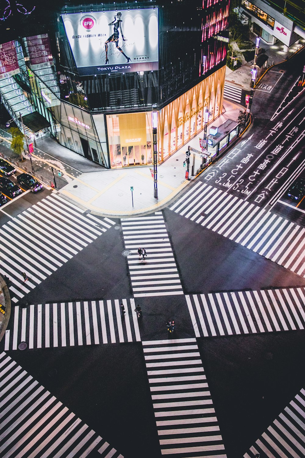 people walking on pedestrian lane in between building during nighttime