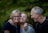photo of two man and one woman standing near tree