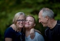 photo of two man and one woman standing near tree