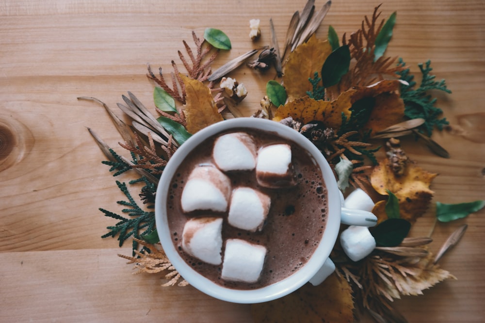 Uma xícara de chocolate quente com marshmallows grandes.