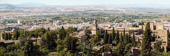 A panoramic view of Luxembourg City's old town with its historic buildings and lush greenery under a clear sky.