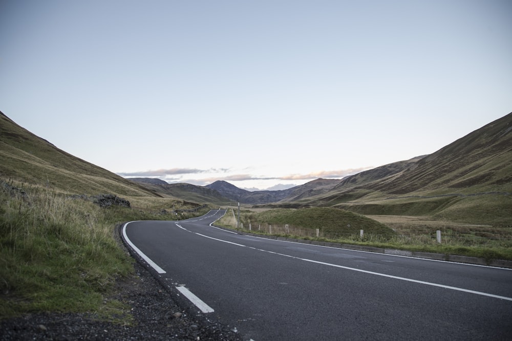 road near grass field at daytime