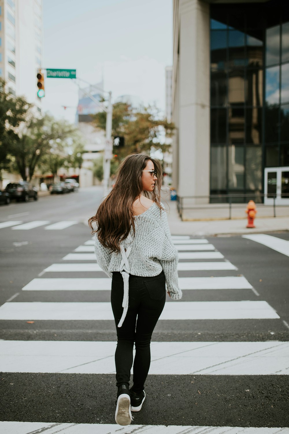 woman looking towards her right while walking along pedestrian lane during daytime