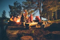 A group of veterans sharing stories around a campfire in a peaceful outdoor setting.