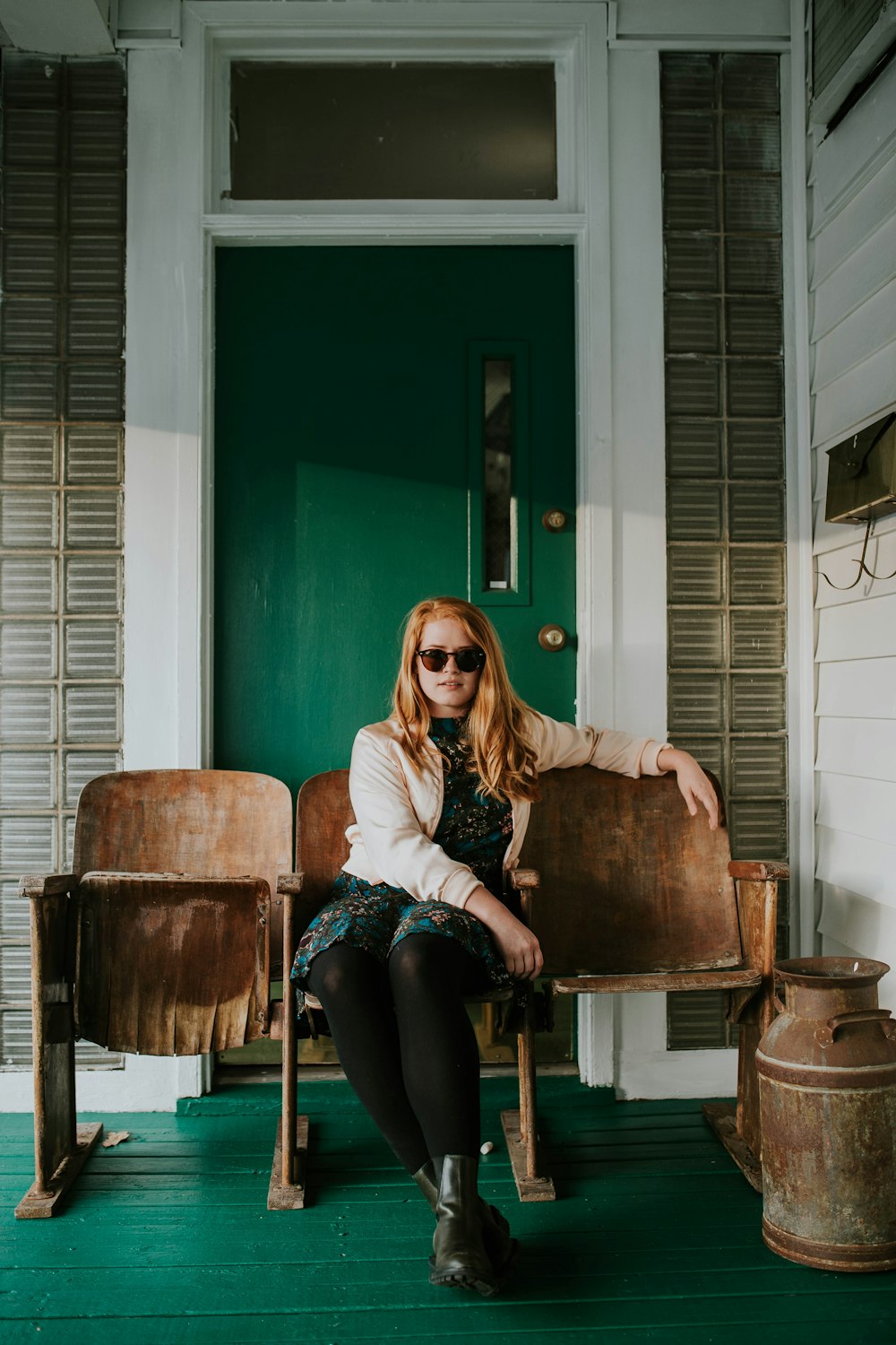 woman in blue dress sitting on brown wooden gang chair during daytime