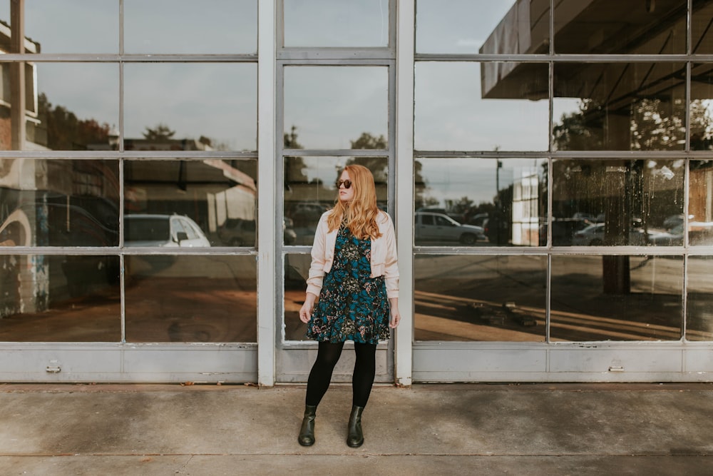 woman wearing pink bolero and black leggings standing in front of glass wall