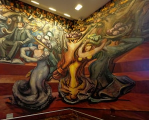 A vibrant mural depicting stylized figures in motion. People are dressed in early 20th-century attire, characterized by top hats and elaborate gowns. The composition features dynamic lines and exaggerated forms, suggesting movement and energy.