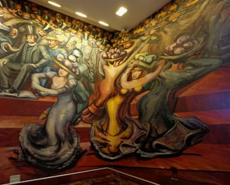 A vibrant mural depicting stylized figures in motion. People are dressed in early 20th-century attire, characterized by top hats and elaborate gowns. The composition features dynamic lines and exaggerated forms, suggesting movement and energy.