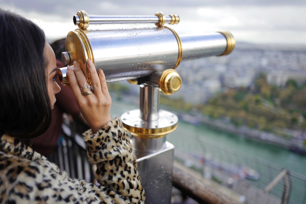 donna che guarda attraverso un telescopio durante il giorno