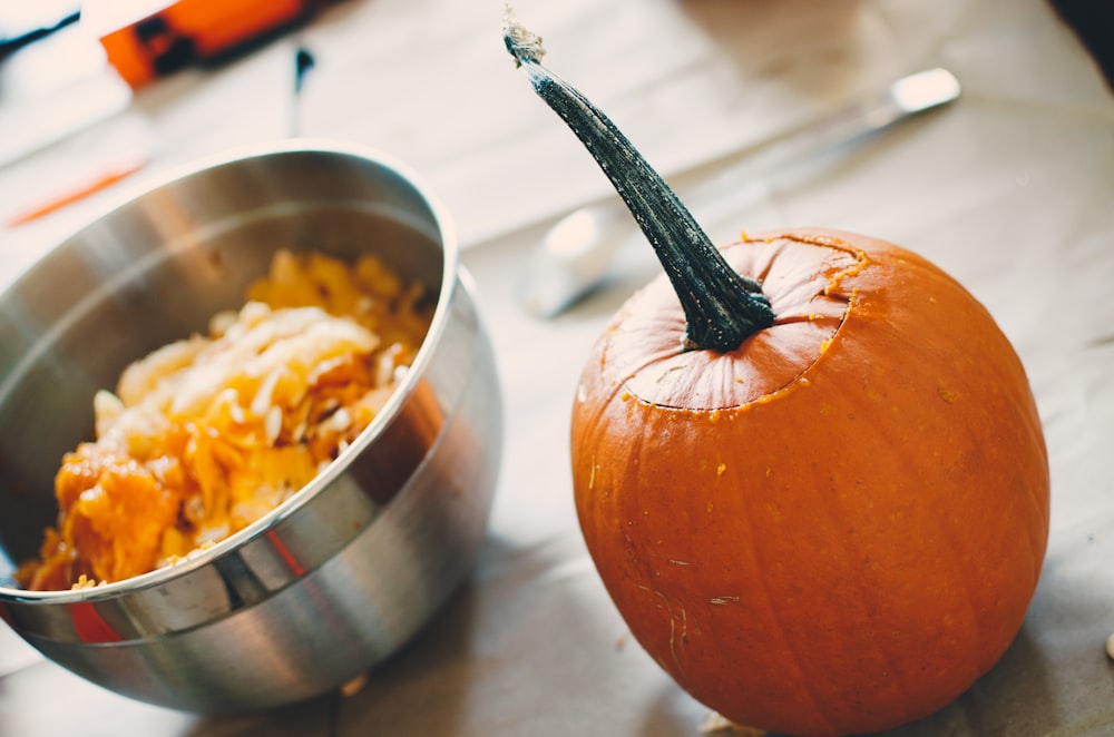 orange squash on table beside steel bowl