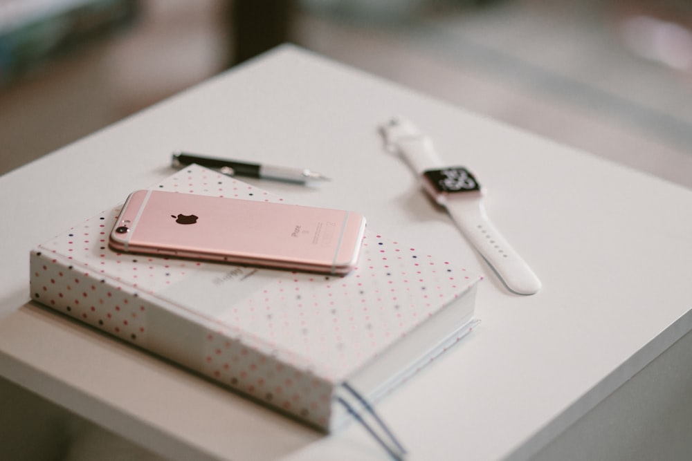 iPhone 6s de oro rosa en un libro cerca del Apple Watch