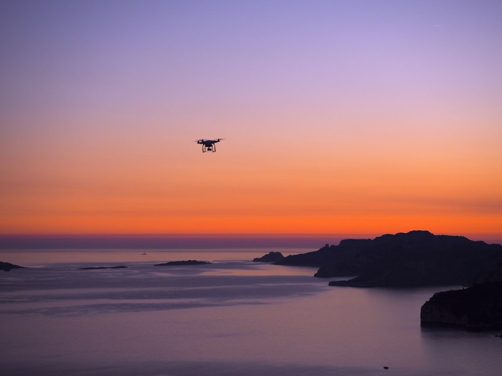 해변에 있는 무인 항공기의 실루엣 사진