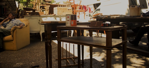 Craftsman carefully restoring an antique chair with new fabric in a bright workshop.