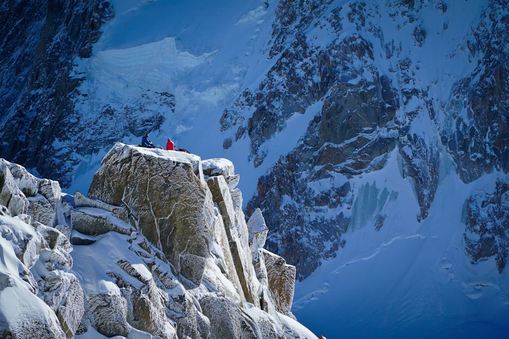 personne debout au sommet d’une montagne enneigée