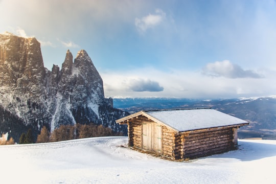 brown wooden house covered with snow in Parco Naturale Sciliar-Catinaccio Italy