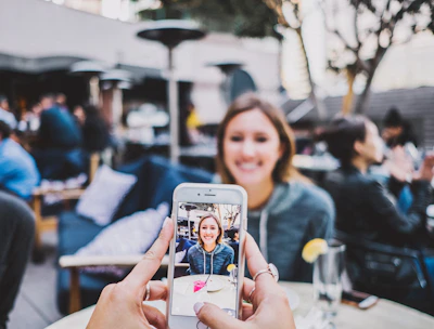 person taking photo of woman