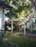 A happy homeowner standing beside their newly built wooden pergola in a sunny backyard.