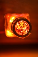 A warm glowing night lamp made from a green glass bottle with delicate fairy lights inside.