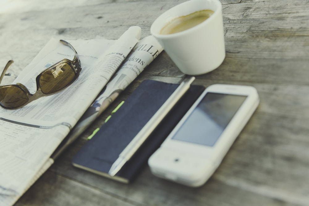 white digital device beside click pen