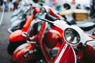 red and white motor scooter parked selective photography