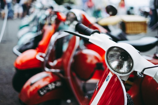 red and white motor scooter parked selective photography