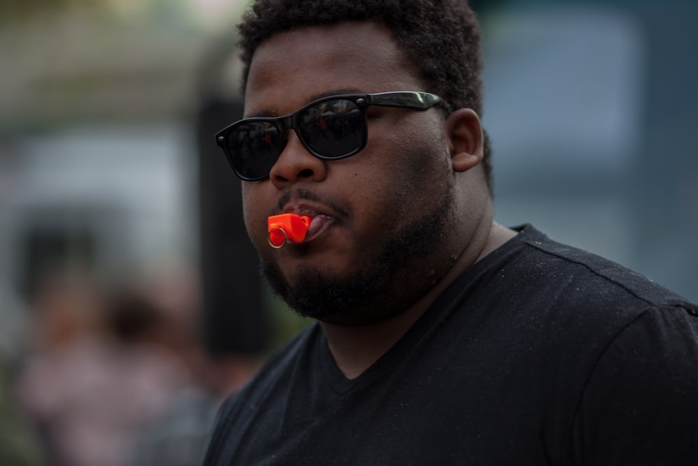 man in black crew neck shirt wearing black sunglasses