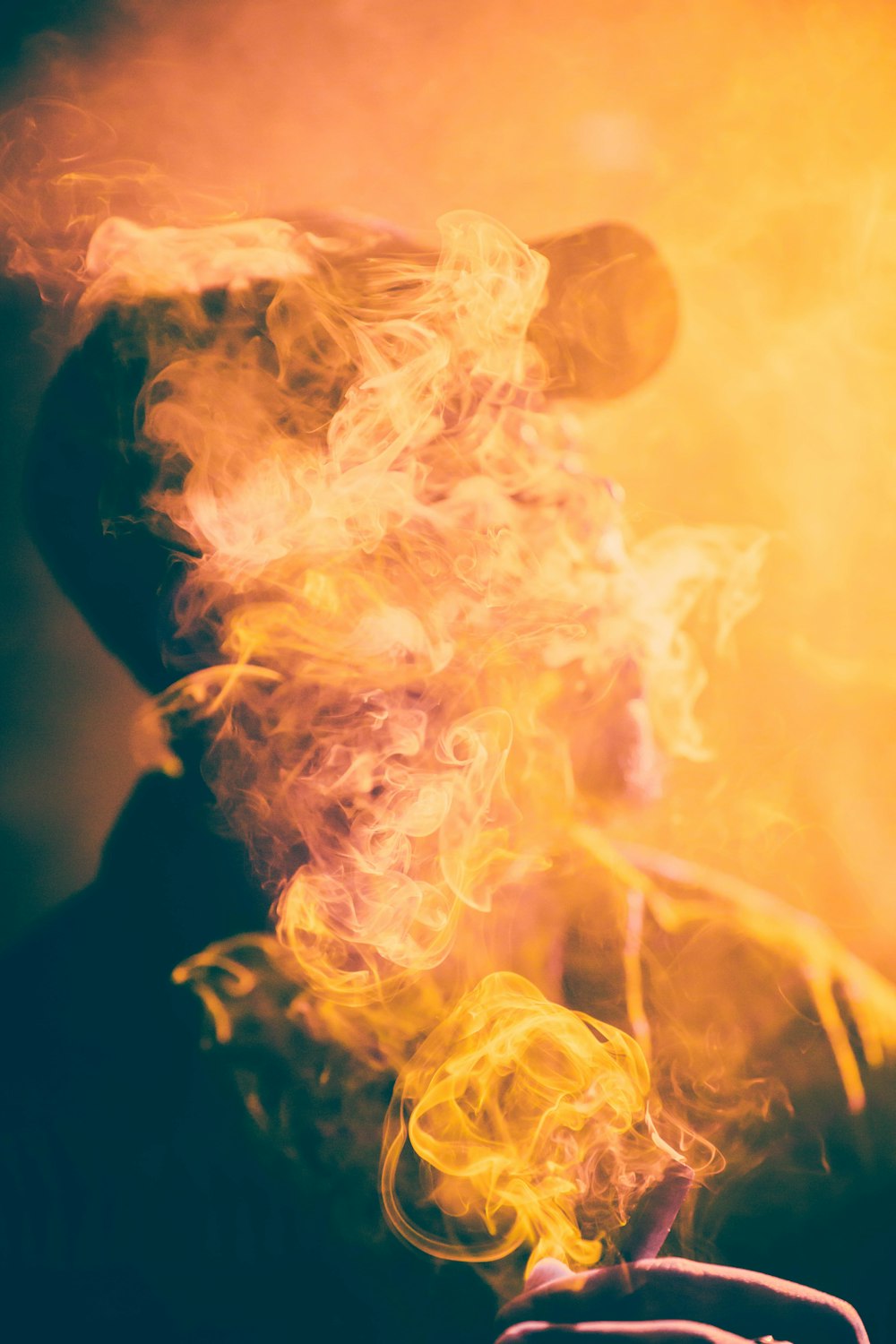 Fotografia macro do homem coberto pela fumaça do charuto