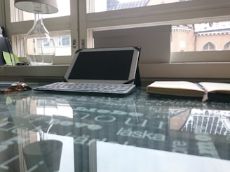 A variety of tablets and notebooks displayed on a modern glass shelf with soft lighting.