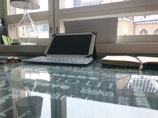 A variety of tablets and notebooks displayed on a modern glass shelf with soft lighting.