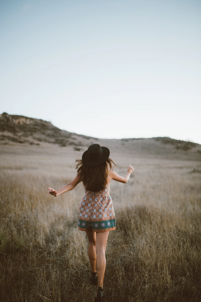 A woman walking barefoot through a soft, grassy field