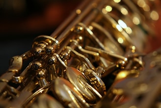 A close-up view of the intricate metal keys and mechanisms of a saxophone, showcasing its shiny gold finish and detailed craftsmanship.