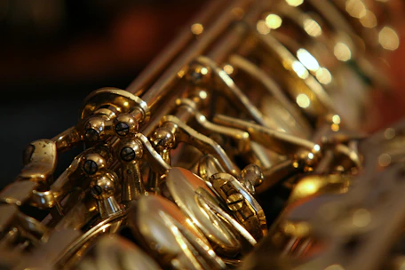 Close-up of a skilled technician adjusting a saxophone’s keys with precision.