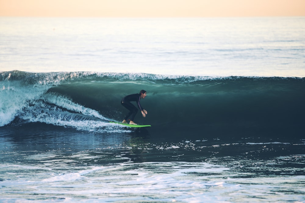 uomo che fa surf sul mare durante il giorno