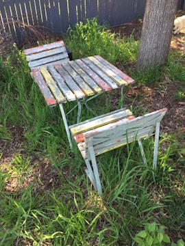 Handmade rustic wooden cornhole boards with natural finish set on the farm’s grassy area near wildflowers.
