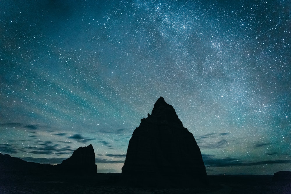 Silhueta da montanha rochosa sob o céu estrelado