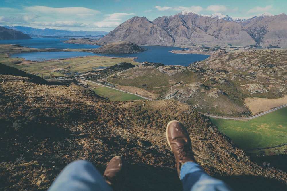 person sitting on cliff during daytime