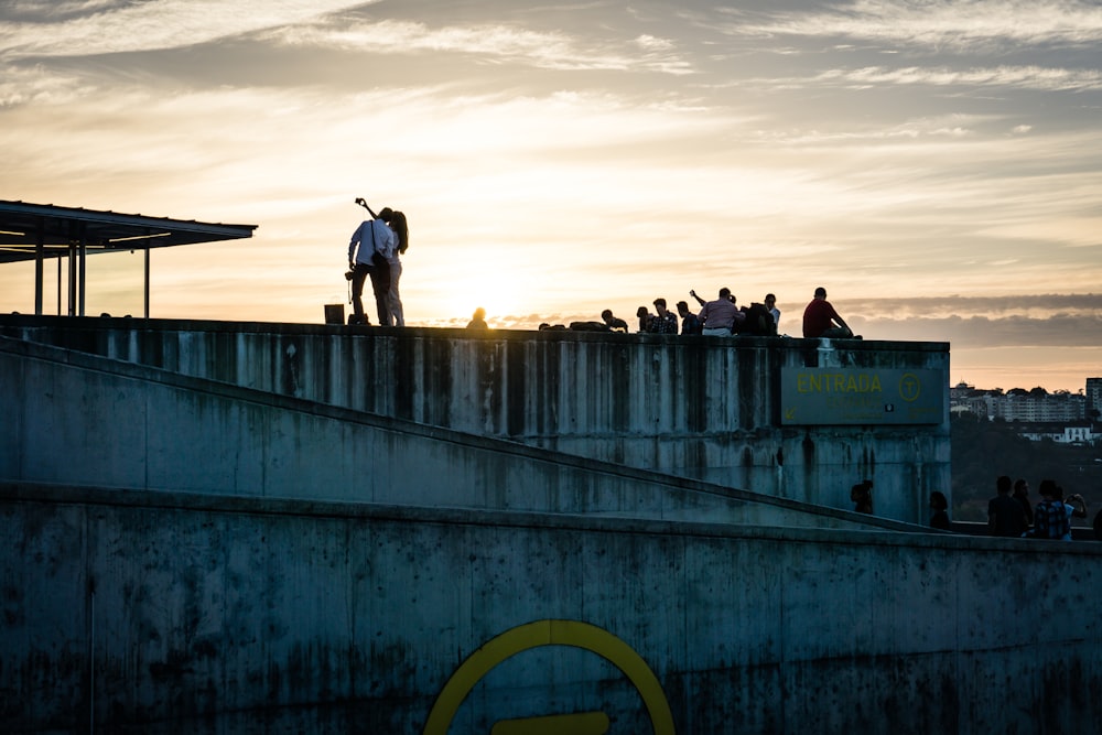pessoas caminhando em ponte de concreto cinza durante o dia