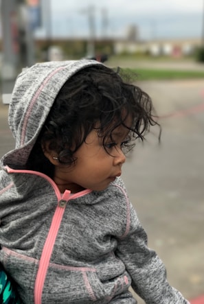 A cozy child wearing a light heather grey hoodie.