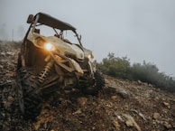Close-up of a Tordis trailer hitch securely attached to an ATV on a muddy trail.