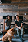 tan dog sitting beside man and woman