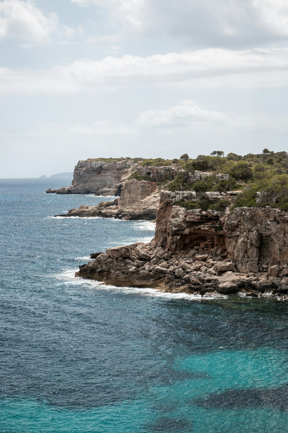 a large body of water next to a rocky cliff