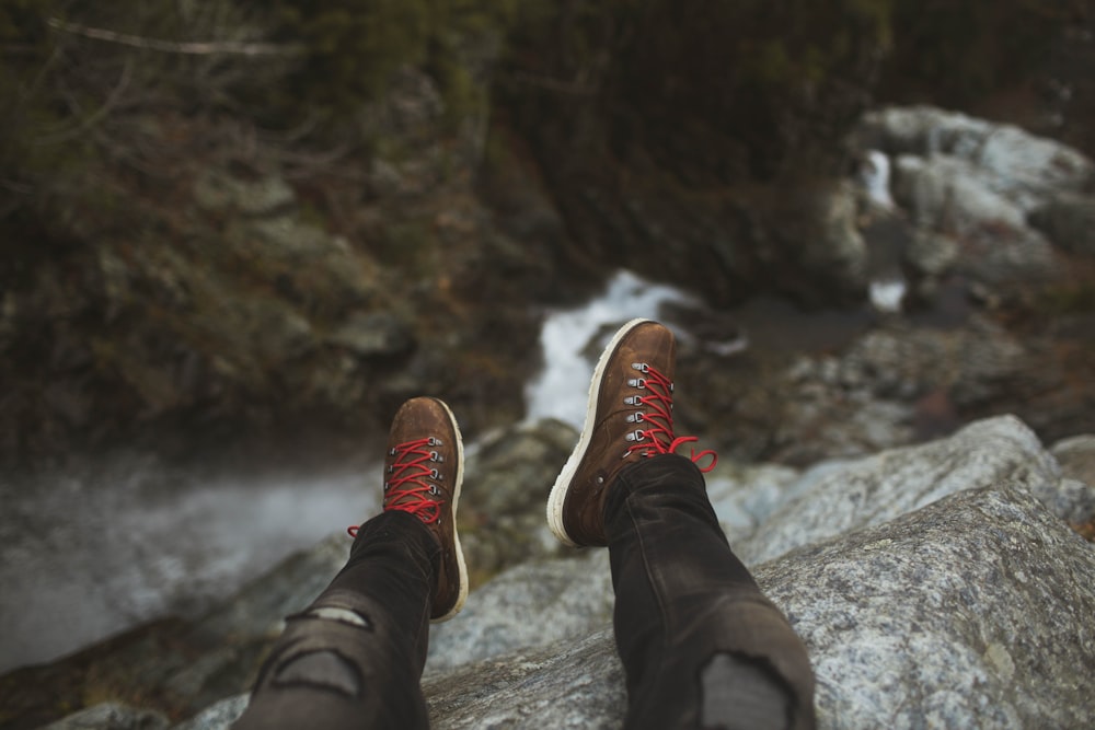 person sitting on rock cliff