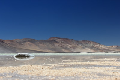 A serene landscape of salt flats under a clear blue sky, showcasing nature's beauty.