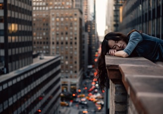 woman leaning on top building rail during daytime