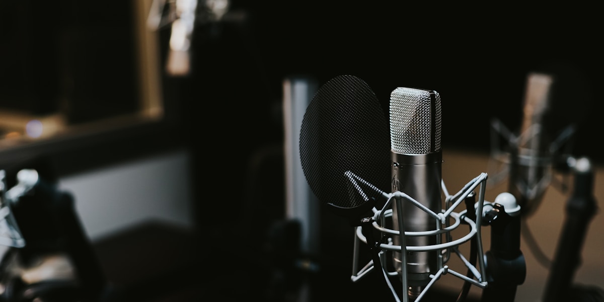 Wywiad Q&A – źródło: Unsplash Mikrofon i notatnik – wywiad z klientem