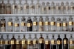 Vintage glass bottles filled with colorful herbal tinctures lined up on a wooden shelf.