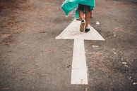 person walking on arrow street sign