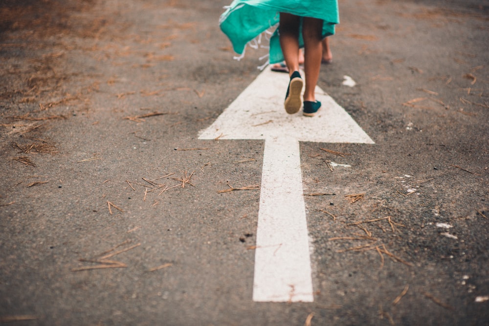 person walking on arrow street sign